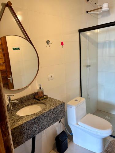 a bathroom with a sink and a toilet and a mirror at Pousada Refúgio das Águas Quarto 3 in Chapecó