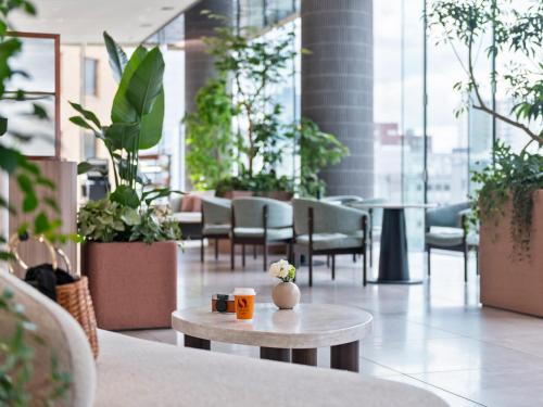 a room with plants and a table and chairs at Mitsui Garden Hotel Sendai - Reopening on June 14 in Sendai
