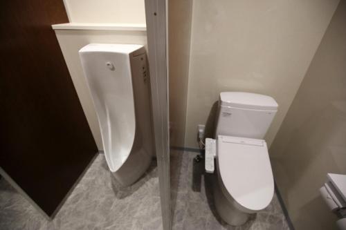 a bathroom with a white toilet and a urinal at Ryokan Koyokan in Yasugi