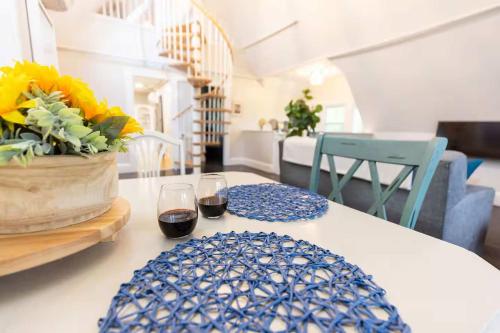 a table with two glasses of wine and a vase of flowers at Jennifer's Unique Loft Near Brown 2 Parking Spots in Providence