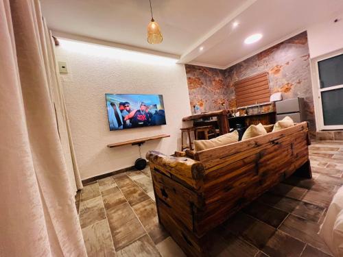 a living room with a couch and a tv on a wall at City Retreat Studio X in Arusha