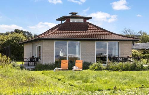 a small house with two chairs in the yard at Cozy Home In Knebel With Wifi in Knebel