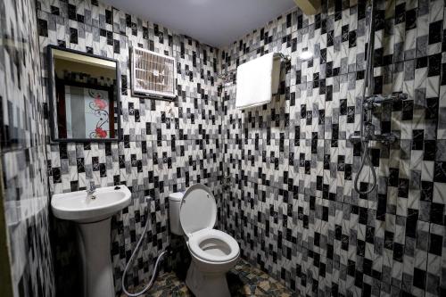 a bathroom with a toilet and a sink at De Gentong Guest House & Cafe By Akasha in Dadapan