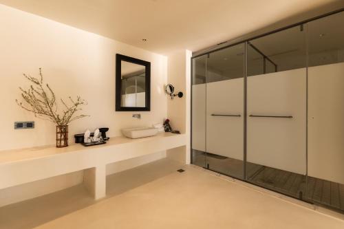 a bathroom with a glass shower stall and a sink at 大理松云悬崖酒店 in Dali Ancient Town