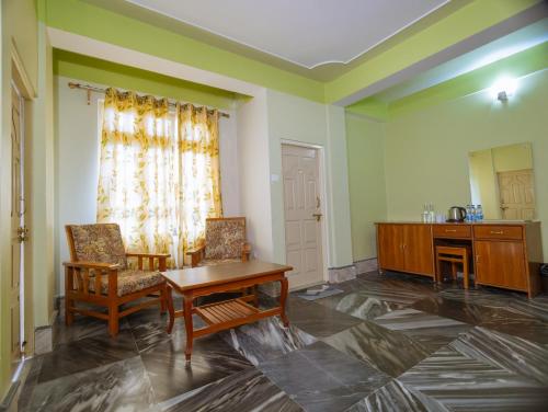 a room with two chairs and a table and a desk at Divyaraa Breathing Stone in Kalimpong