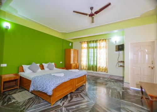 a bedroom with a bed with green walls and a ceiling at Divyaraa Breathing Stone in Kalimpong