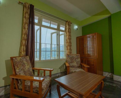 a living room with a table and chairs and a window at Divyaraa Breathing Stone in Kalimpong