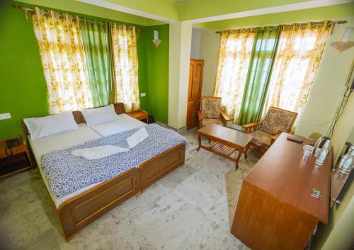 a bedroom with a bed and a table and chairs at Divyaraa Breathing Stone in Kalimpong