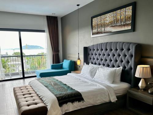 a bedroom with a large bed and a blue chair at KEP BAY HOTEL & RESORT in Kep