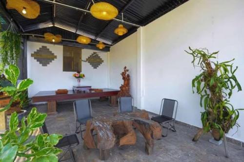 une pièce avec une table et des chaises en bois et une table avec une souche d'arbre dans l'établissement T'Homestay garden villa, à Thôn Lại Thê