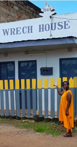 a man in an orange dress standing outside of a house at Wrech House Sagana -1989 PAY BEFORE ARRIVAL in Sagana