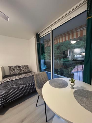 une chambre avec un lit, une table et une fenêtre dans l'établissement Grand Studio Lumineux et Fonctionnel 4 couchages Gare routière, à Menton