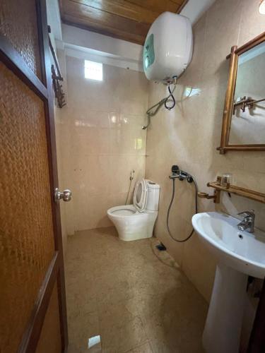 a bathroom with a toilet and a sink at Quế Homestay in Hòa Bình