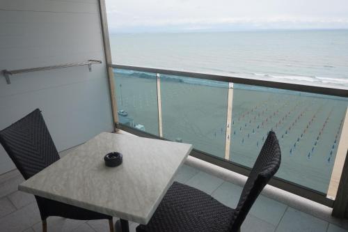a table and chairs with a view of the ocean at Hotel Columbus in Lignano Sabbiadoro