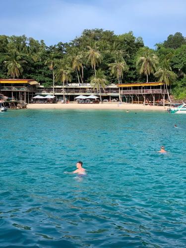 two people swimming in the water near a beach at Phu House in Phu Quoc