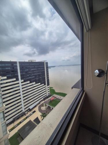 a view of the water from a hotel room window at Suite Luxury en Puerto Santana in Guayaquil