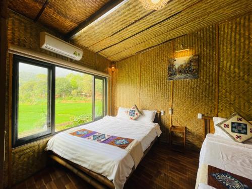 a bedroom with two beds in a room with a window at Quế Homestay in Hòa Bình