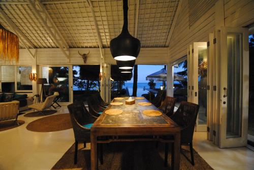 a dining room with a wooden table and chairs at Beach Villa Pantai Matanai in Tianyar