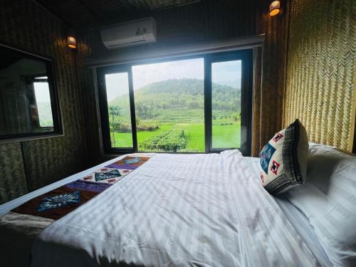 a bedroom with a bed and a large window at Quế Homestay in Hòa Bình