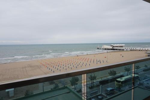 a view of a beach and the ocean from a building at Hotel Columbus in Lignano Sabbiadoro