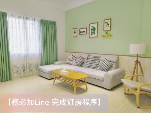 un soggiorno con un divano e un tavolo di 荷風緩緩包棟民宿 a Jiaoxi