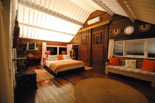 a bedroom with a bed and a couch in a room at Beach Villa Pantai Matanai in Tianyar