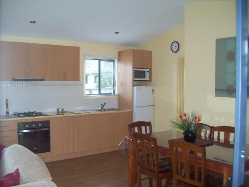 a kitchen and dining room with a table and chairs at Koonwarra Holiday Park in Lakes Entrance