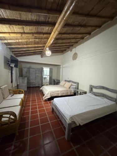 a bedroom with two beds and a couch in it at Ecohotel Santa Barbara in Circasia
