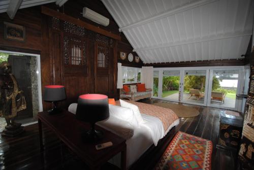 a bedroom with a bed in a room with wooden walls at Beach Villa Pantai Matanai in Tianyar