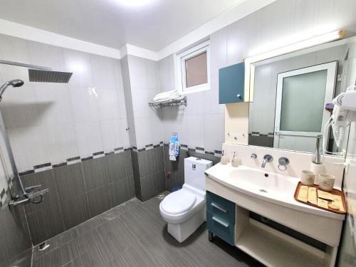 a bathroom with a toilet and a sink and a mirror at Top Hill Halong in Ha Long