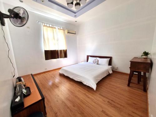 a bedroom with a bed and a desk and a window at Top Hill Halong in Ha Long
