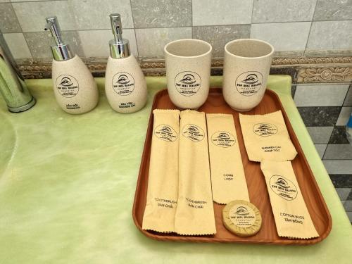 a tray with four toothbrushes and three cups on a counter at Top Hill Halong in Ha Long