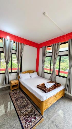a bedroom with a bed in a room with windows at Lhamu homestay in Chug