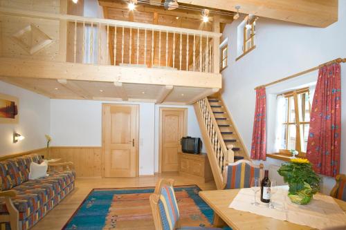 a living room with a staircase and a couch and a table at Pension Breitenlohner in Reit im Winkl