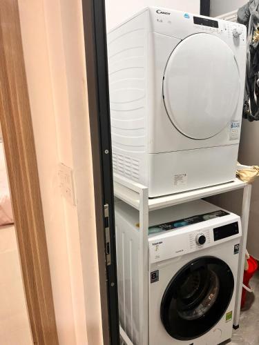a washing machine and a dryer with a mirror at Châu Giang Homestay, Nera Garden Huế in Thôn Văn Dương