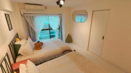 a bedroom with two beds and a window at Stunning luxury APT with balcony in Tokyo Shinjuku Kabukicho in Tokyo