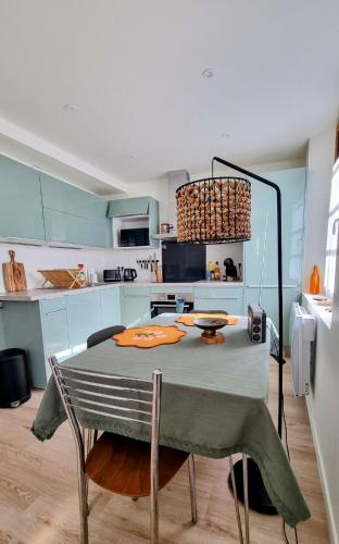 une cuisine avec une table et une cuisine avec des armoires bleues dans l'établissement Chez Marie, Plage 420m, Batz sur Mer, 2 pers, BB -9m, à Batz-sur-Mer