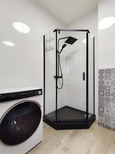 a shower with a glass door next to a microwave at Toscany de LUX samo centrum in Bielsko-Biała