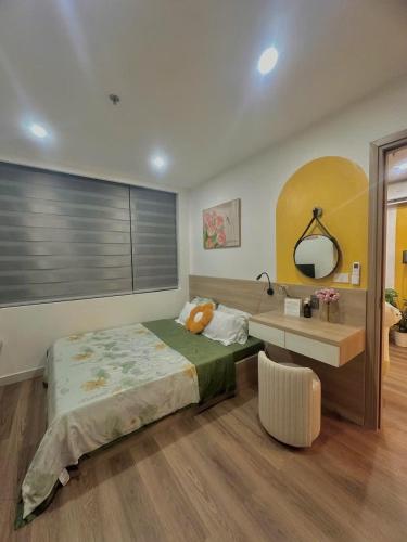 a bedroom with a bed and a desk and a mirror at Châu Giang Homestay, Nera Garden Huế in Thôn Văn Dương