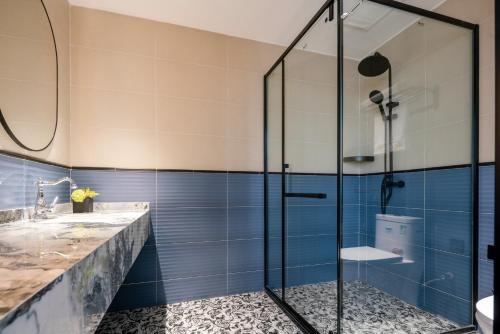 a glass shower in a bathroom with blue tiles at 重庆大野江景民宿 in Chongqing