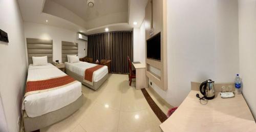 a hotel room with two beds and a television at Marino Hotel - Best near Airport in Dhaka