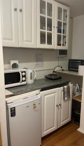 a kitchen with white cabinets and a white refrigerator at Vista a la bahía in Valparaíso