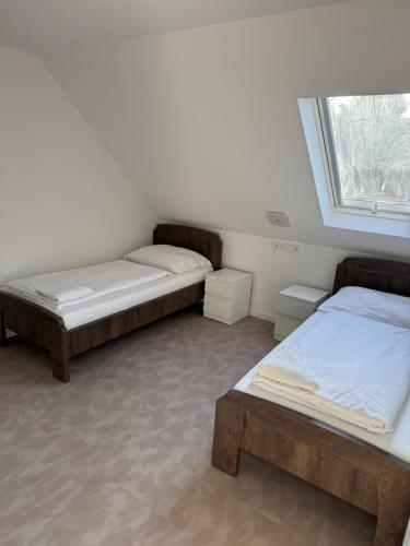 two beds in a room with a window at Mineral Zafír apartman in Nyíregyháza