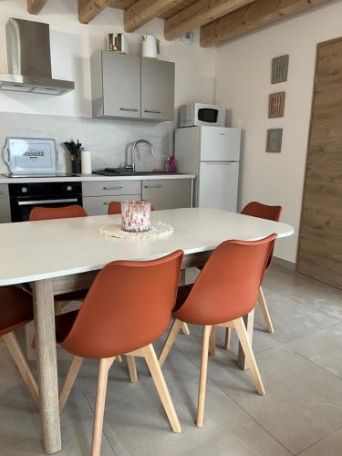 - une cuisine avec une table et des chaises blanches dans l'établissement Appartement proche du lac de Vouglans, à Charchilla