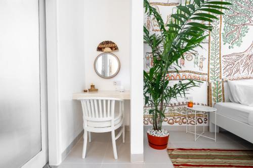a bedroom with a table and a chair and a plant at Eiwa House in Ubud