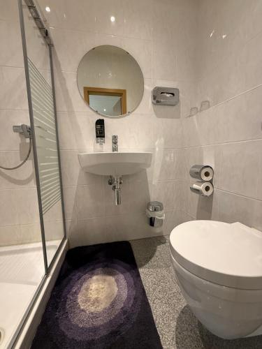 a bathroom with a toilet and a sink and a mirror at Pension Cao Lai in Varel