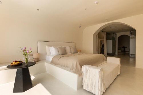 a white bedroom with a bed and a table at 大理松云悬崖酒店 in Dali Ancient Town