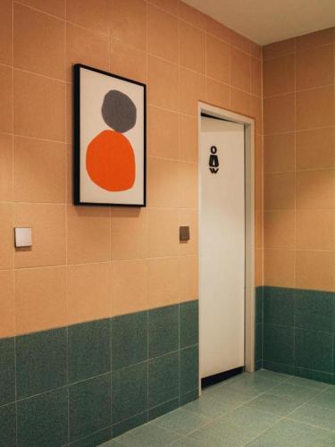 a bathroom with a picture on the wall and a door at 777Bliss Hometel in Nakhon Phanom