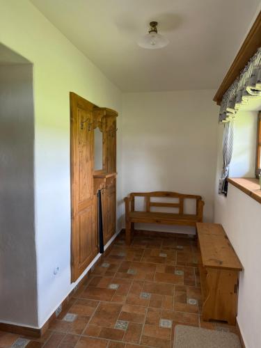 a room with a table and a wooden door at Chaloupka Pomněnka na Lipce in Nasavrky
