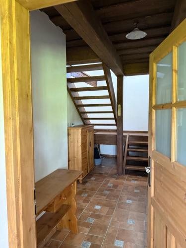 a room with a wooden table and a wooden door at Chaloupka Pomněnka na Lipce in Nasavrky